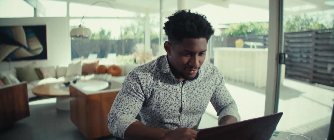 Man sitting at a table in front of a laptop computer