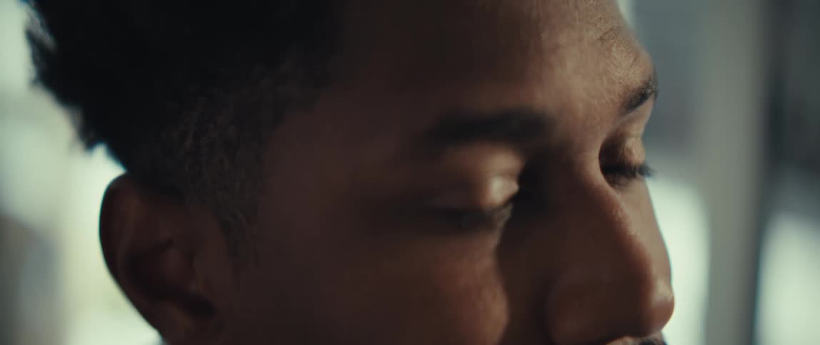 A close up of a black mans face who appears sad and nervous