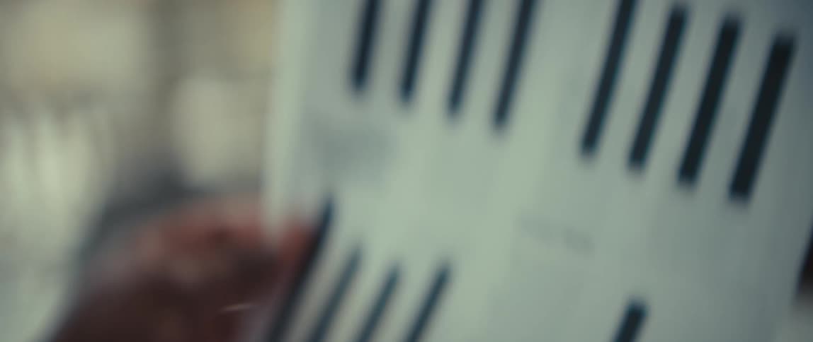 An up close look at a black man who is reading a document with graphs
