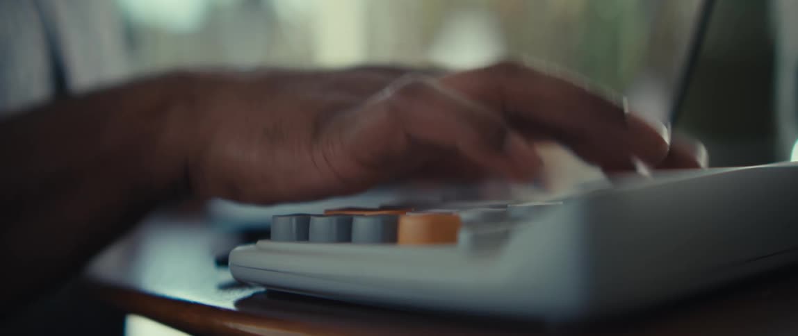 A close up of a persons hands typing on a vintage mechanical keyboard