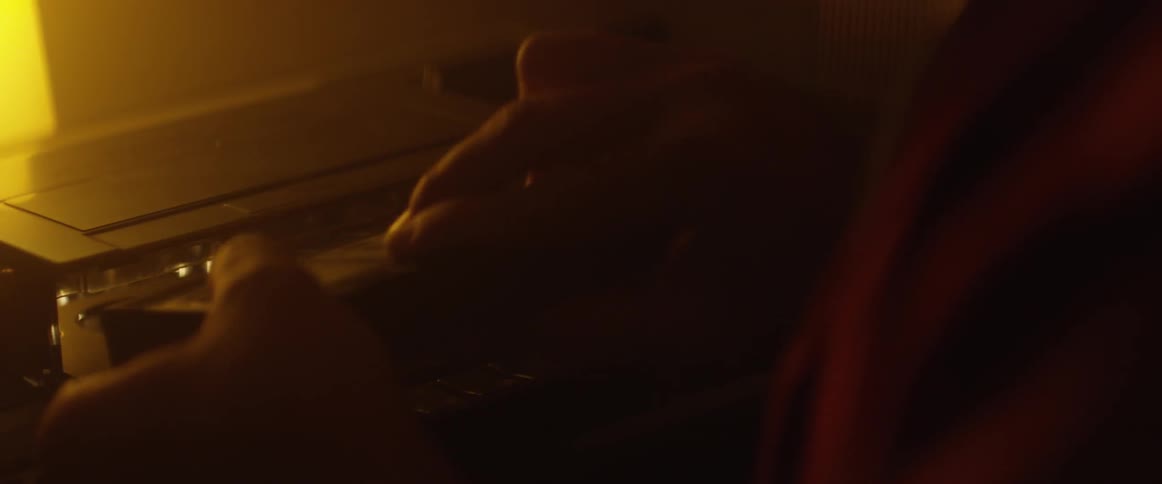 A man puts a cassette into a cassette player