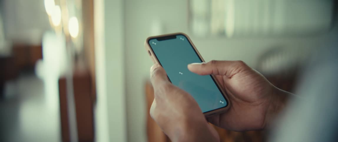 Person holding a smartphone and tapping the screen