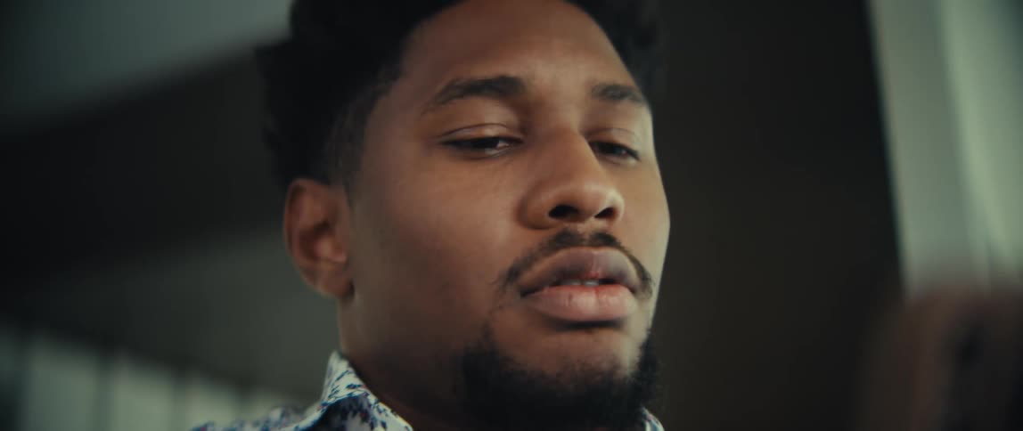 The video shows a closeup of a man looking intently at his smartphone he appears focused and slightly concerned as he scrolls through the content on his screen