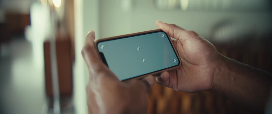 Human adult male black hands holding a smartphone with a replaceable screen in a room indoors during day time