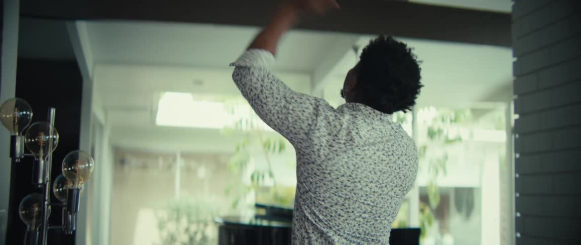 The man walks through his home cheering at his phone
