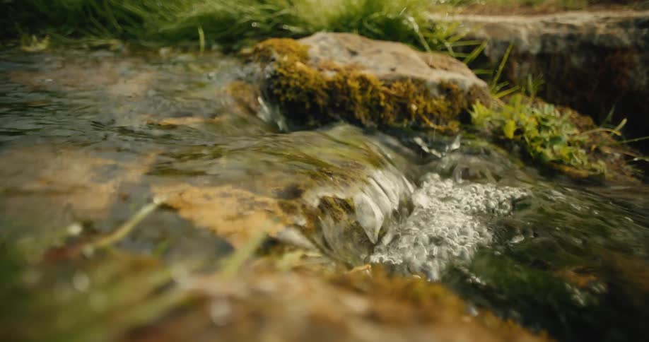 Flowing water running over mosscovered rocks