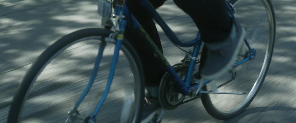 Person pedaling a bicycle down a street