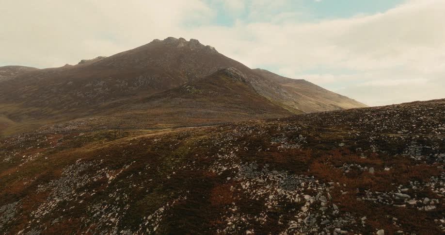 Mountain peak on rocky terrain with sparse vegetation