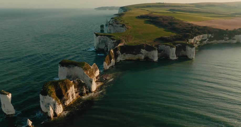 Seagulls fly over the white chalk cliffs of the old harry rocks on the jurassic coast dorset