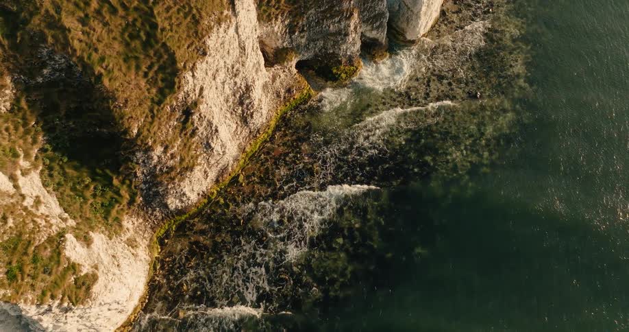 Waves are crashing against the cliff and large rocks