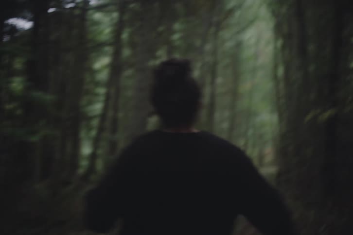 A woman running through a forest