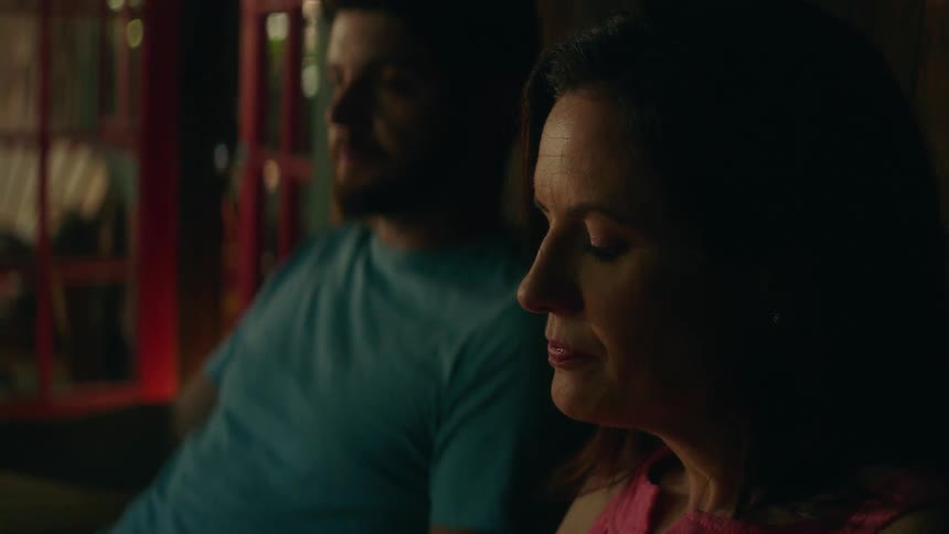 A man and woman sip iced tea on a porch