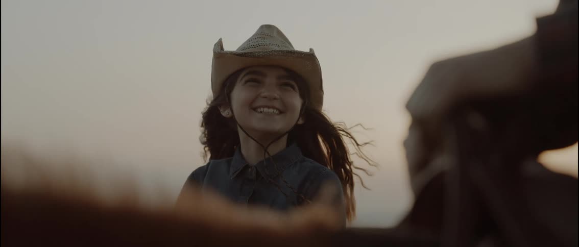 The girl is laughing on the horse