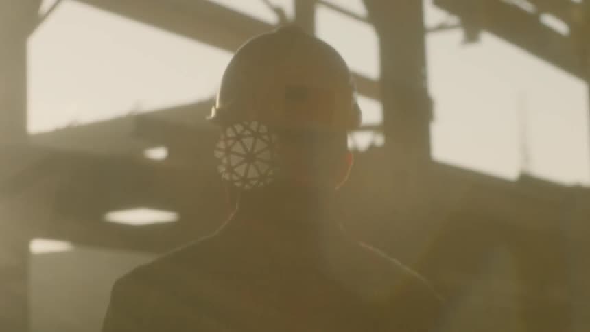 Man wearing a hardhat stands in a smoky construction area