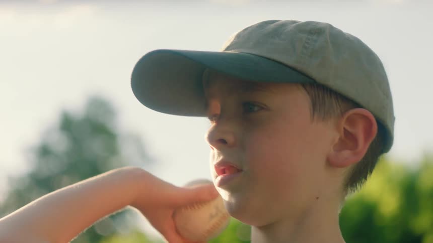 Child wearing a baseball glove throws a baseball