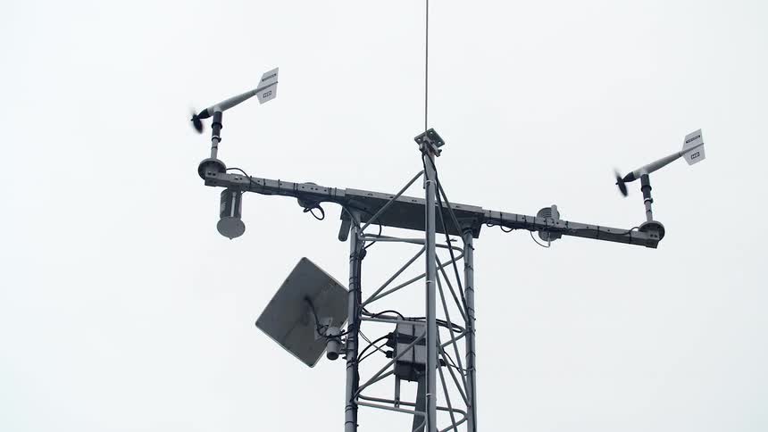 Antenna with multiple sensors stands under a pale sky