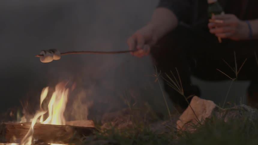 Person roasts marshmallows over a campfire