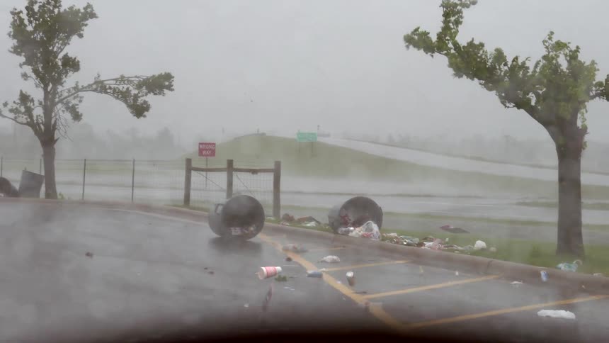 The strong winds the garbage cans across the lot