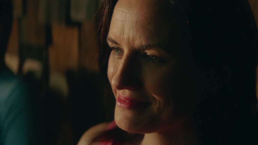 A woman looks forward and smiles