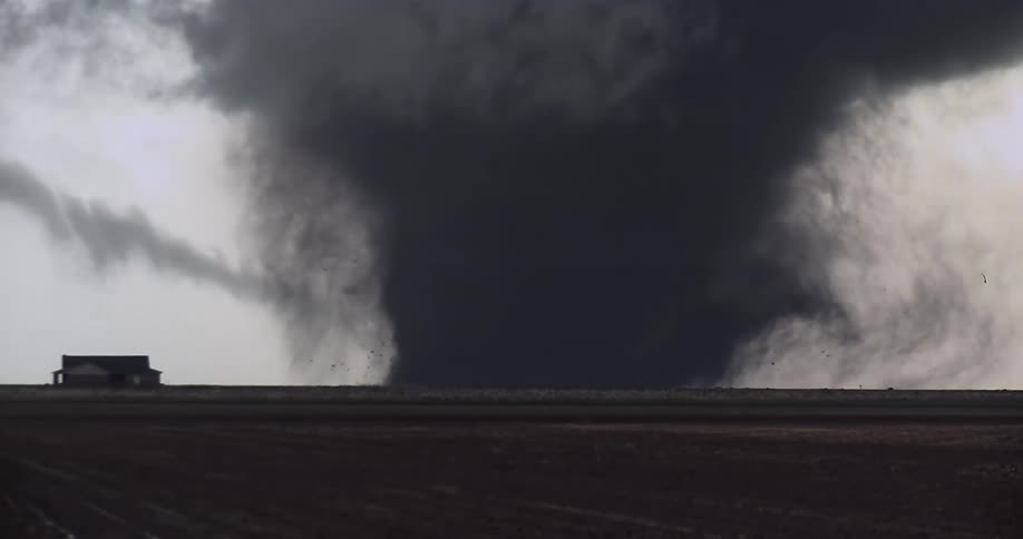 A tornado with lightning coming off of it in a rural area
