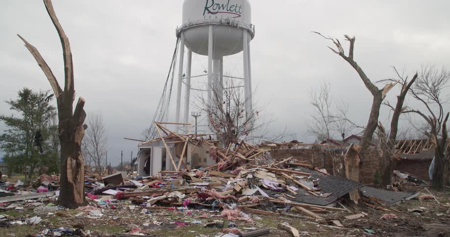A water tower stands over the ruins of a home destroyed by a tornado