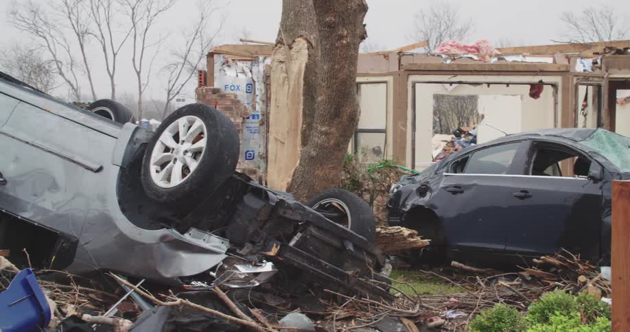A view of a house and cars that have been destroyed