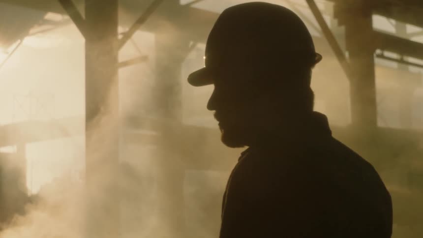 Man wearing a hardhat stands in a smoky construction area