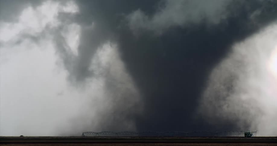Intense tornado with a large debris column over flat farmland