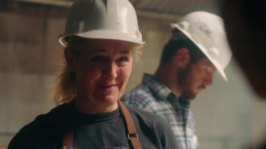 Workers wear hard hats inside a building