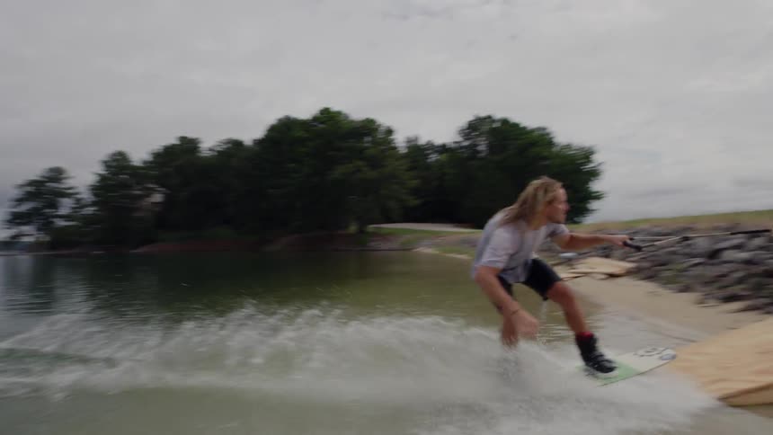 A man is pulled on a board through the water onto land
