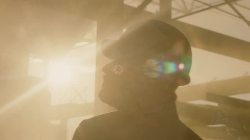 A man wearing a hard-hat is walking in a construction site
