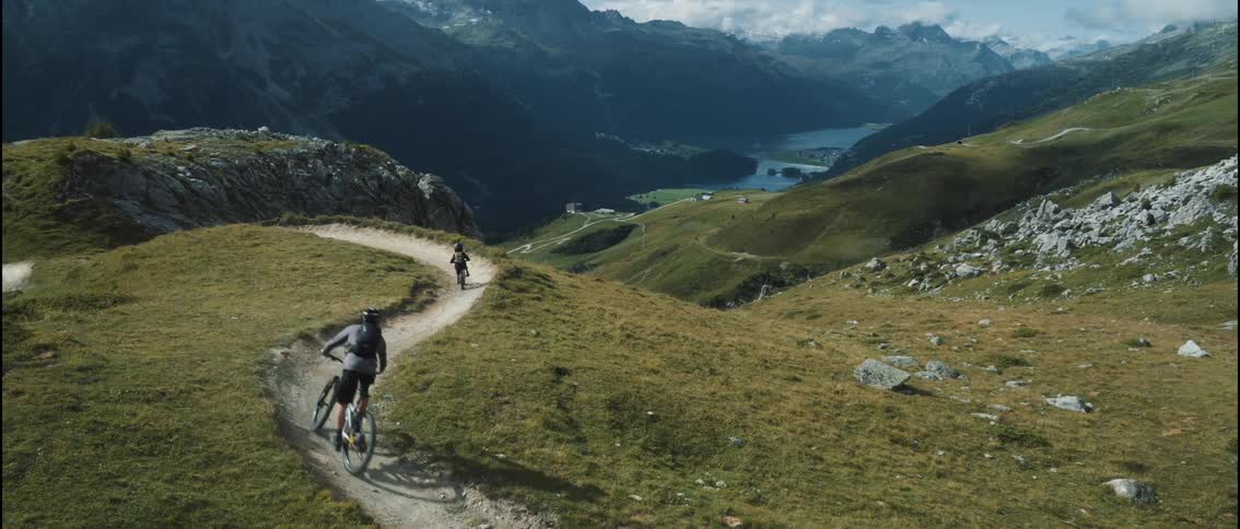 Two people ride their bicycles on the mountain trail
