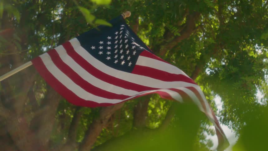 An american flag is hung on the porch of a house