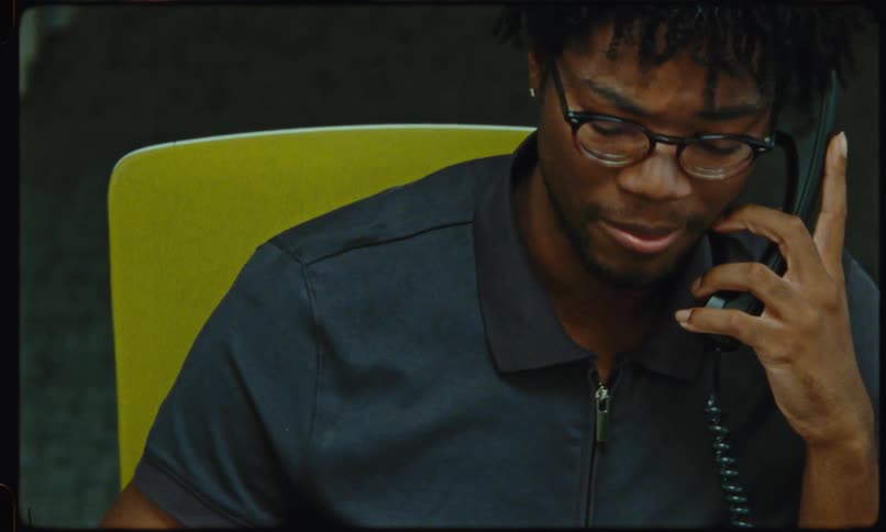 Man sitting in an office talks on a landline