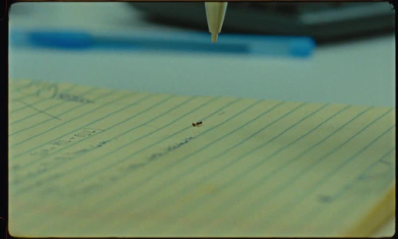 Tip of a pen is trying to kill an ant on a piece of paper