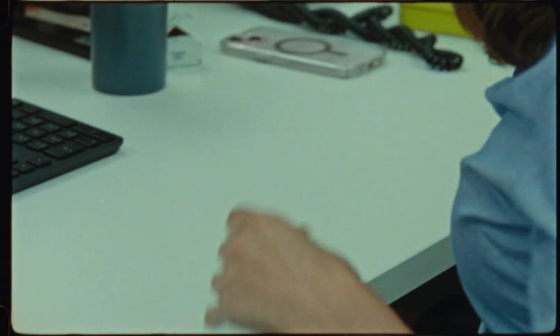 Hands holding a blue folder with documents on a white desk