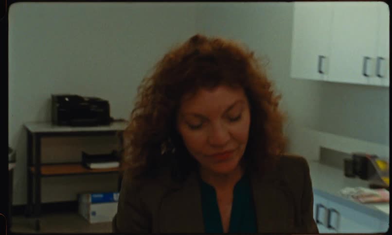 Woman retrieves document from the printer before walking through the room stopping in the doorway in shock