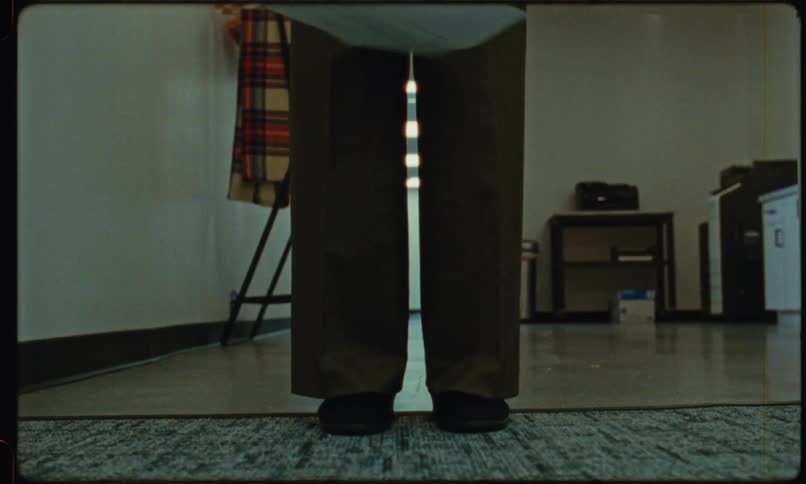 Sheets of paper falling in front of a person standing on carpet indoors