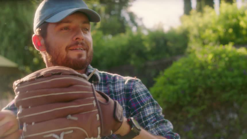 Man wearing a baseball glove throws a baseball
