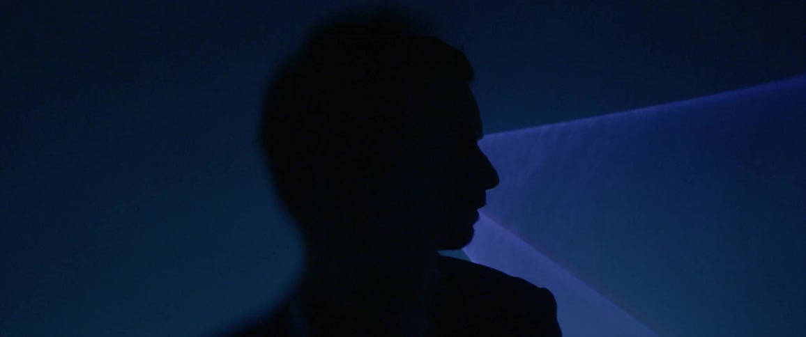 A man stand in front of a laser light