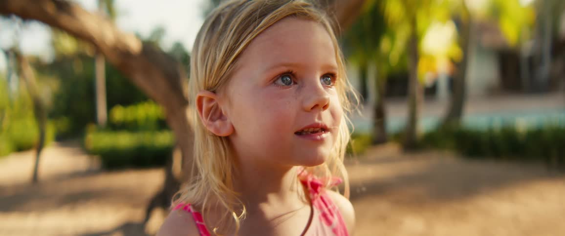 Blonde girl looking upward in a sunny outdoor area