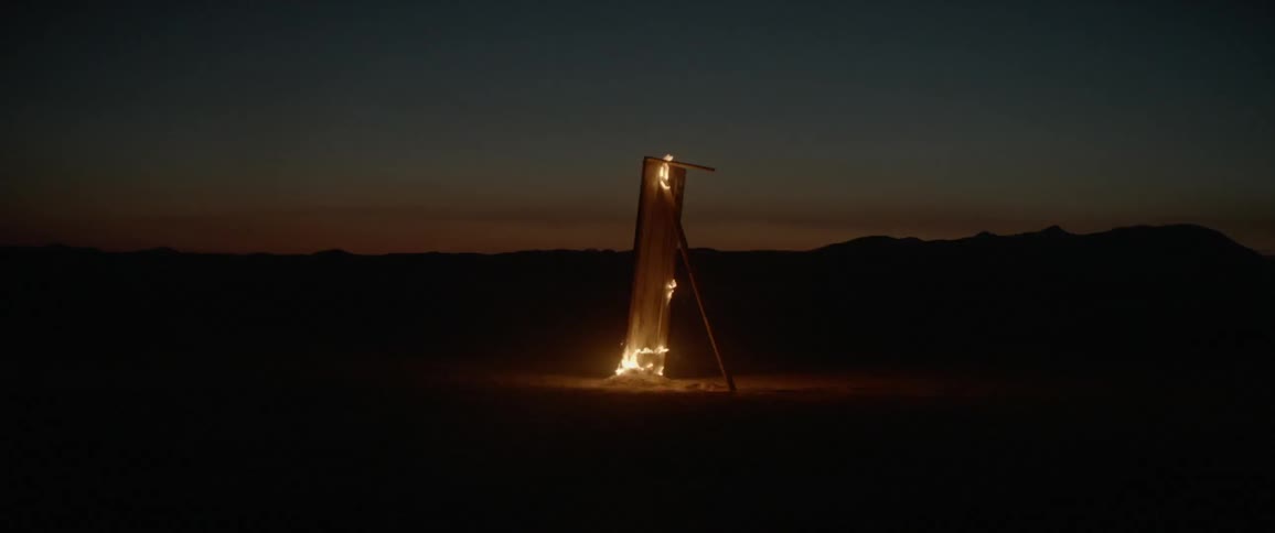 A tall platform is on fire at dawn