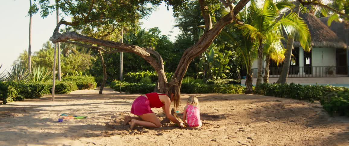 Mother and daughter building a sand castle on a sunny day