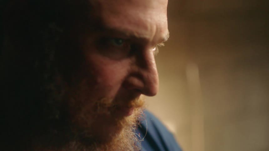 A bearded man looks up and smiles