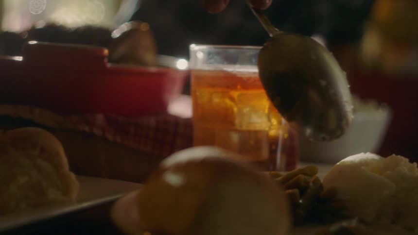 Close up of a drink and snack foods and a smiling man