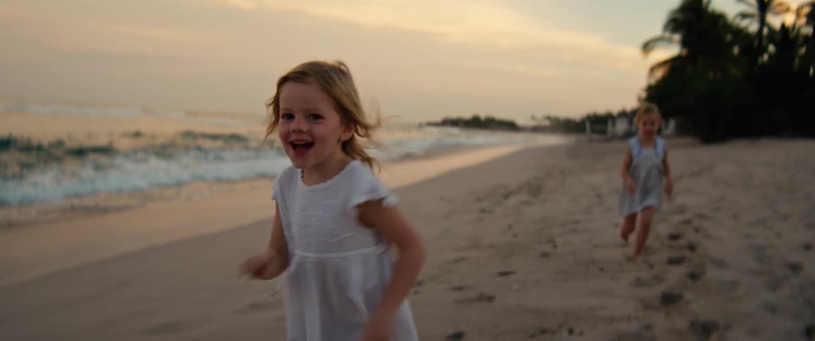 Sisters run on the beach happily near sunset in summer