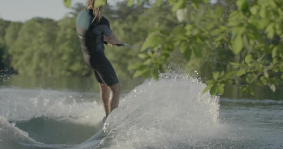 A man jumps onto a board and is pulled away by a boat