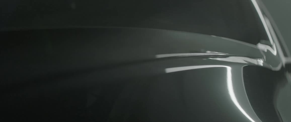 Lights shine and reflect on a car fender