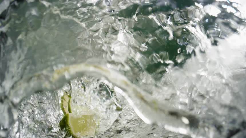 Light shines through the water churning around lime wedges and creating clear waves