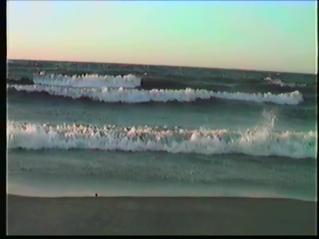 Waves breaking on the beach with a stretch of sand in the foreground